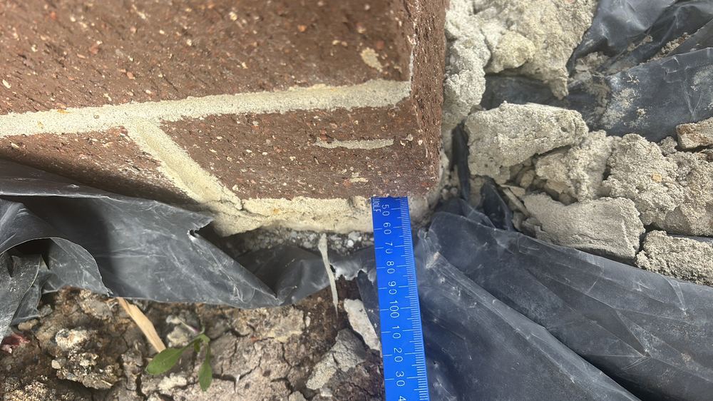 Bottom brick course overhanging the slab edge by more than 15mm, found during a fixing inspection in Hoppers Crossing